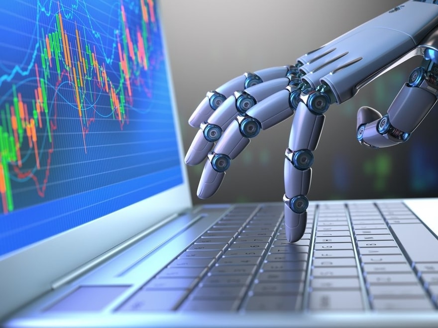 The hand of a robot typing on a laptop with stock charts on a screen | Investment U